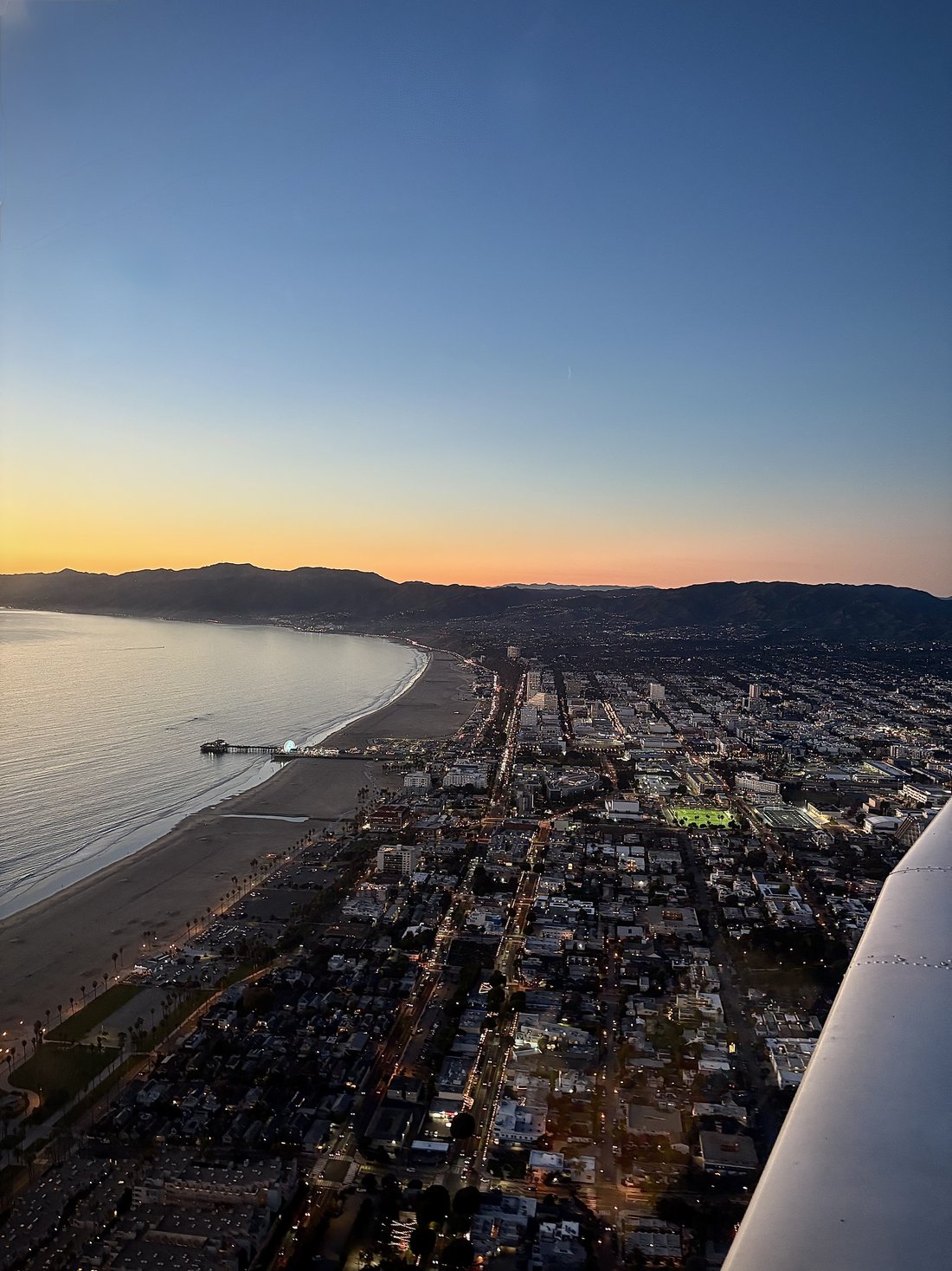 Coastal city at dusk viewed from a small aircraft